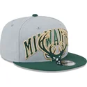 gorra-plana-gris-y-verde-snapback-9fifty-tip-off-2023-de-milwaukee-bucks-nba-de-new-era